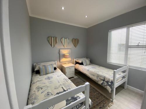 a bedroom with two beds and mirrors on the wall at Net Hier in Eersterivierstrand