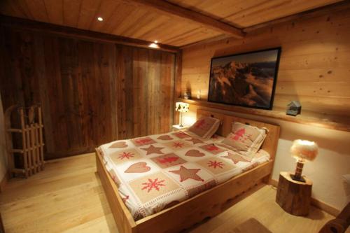 una camera da letto con letto in una camera in legno di appartement cozy dans chalet 6 pers voiture 4 roues motrice a dispo a La Clusaz