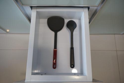 a white box with two spoons in it at Elegant Studio Parkland Avenue Apartment By Travelio in Babakan
