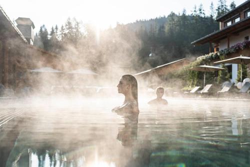a woman standing in the water in a hot tub at BAD MOOS - Aqua Spa Resort in Sesto