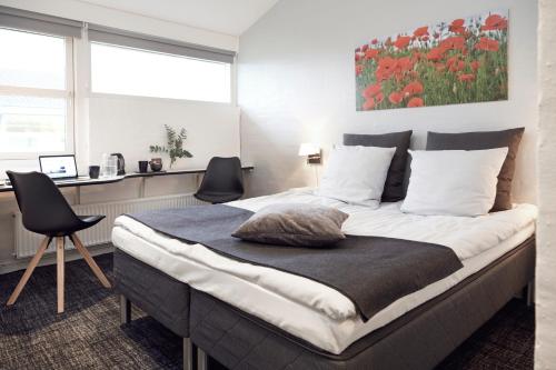 una camera da letto con un grande letto con due sedie di HORISONT Hotel & Konference a Arhus