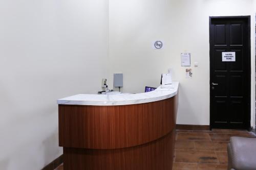 a bathroom with a sink and a black door at Hotel O Point Inn in Jakarta