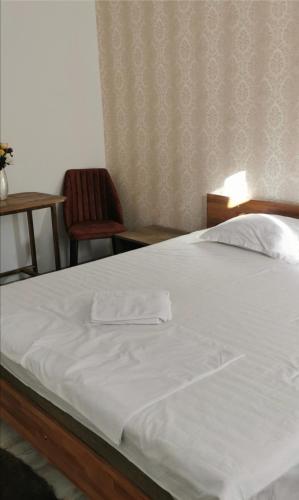 a bed in a bedroom with a white bedsheet at HABIBI in Paşcani