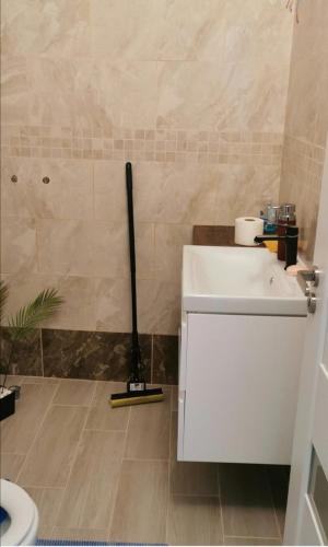 a bathroom with a mop next to a white sink at HABIBI in Paşcani