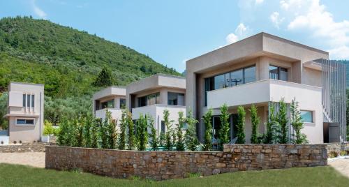 a modern house with a stone wall at SunBlue Boutique Villas in Skala Rachoniou