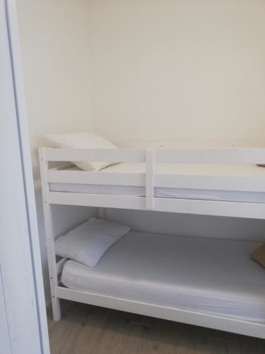 マトゥリにあるMatejの白い二段ベッドが備わる客室です。
