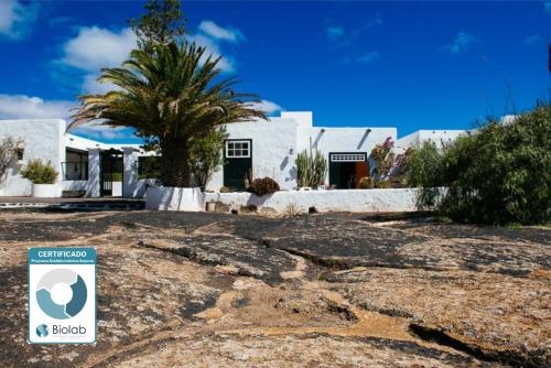 a house with a sign in front of it at Hotel Bodega EL GRIFO in San Bartolomé