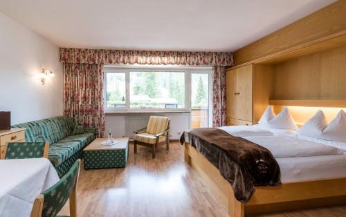een hotelkamer met een bed en een bank bij Residence Bad Moos in Sesto