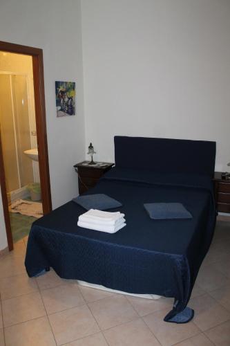 ナポリにあるB&B Villa in Rivieraのベッドルーム1室(ブルーベッド1台、タオル付)