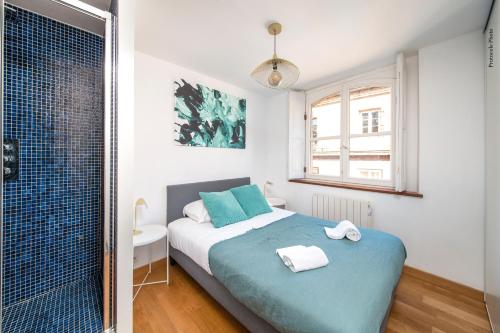 a bedroom with a blue bed and a shower at NOCNOC - Le Mosaïque, centre Toulouse in Toulouse
