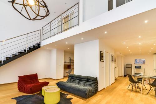 un salon avec un canapé et un escalier dans l'établissement High Standing Comfortable Loft 125m2 city center, à Strasbourg