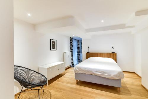 - une chambre avec un lit et une chaise dans l'établissement High Standing Comfortable Loft 125m2 city center, à Strasbourg