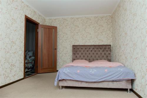 una camera con un letto in una stanza con carta da parati di Охайна двокімнатна квартира біля Дніпра! a Čerkasy