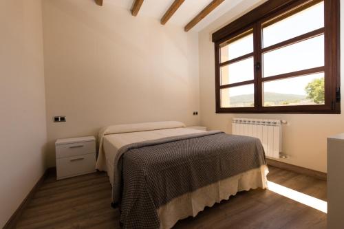 a bedroom with a bed and a window at Posada Sierra de la Culebra in Ferreras de Abajo