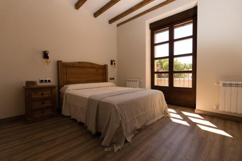 um quarto com uma cama grande e uma janela em Posada Sierra de la Culebra em Ferreras de Abajo