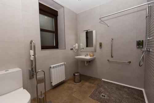 a bathroom with a sink and a shower and a toilet at Posada Sierra de la Culebra in Ferreras de Abajo