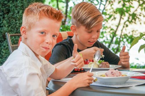 two young boys sitting at a table eating food at Hotel Lamm in Ostfildern
