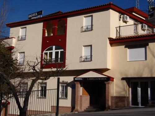 un gran edificio blanco con balcón rojo en Labella María, en Pinos Genil