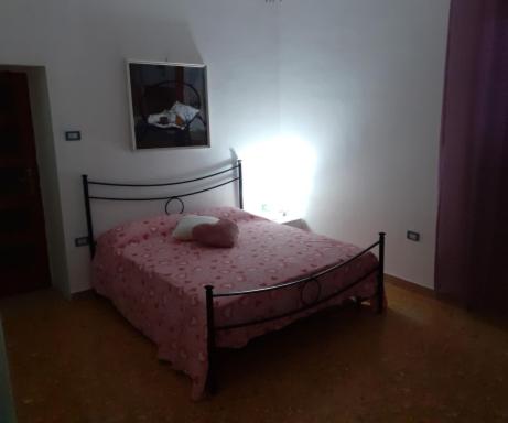 a bedroom with a pink bed with a stuffed animal on it at A casa di Adele in Caserta