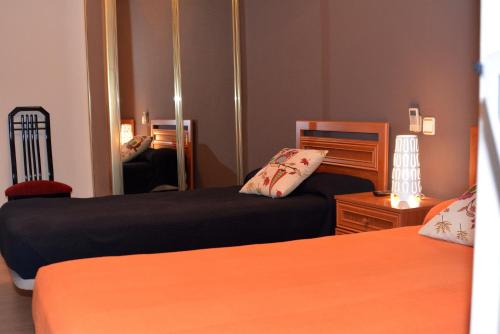 sypialnia z 2 łóżkami i lustrem w obiekcie Hostal Gastrobar Carmelo w mieście Villarejo de Salvanés
