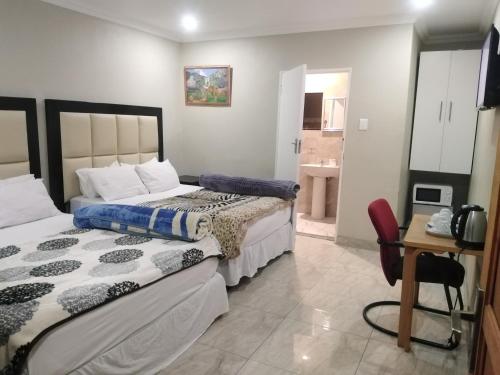 a bedroom with two beds and a bathroom at Classic-Lodge in Kempton Park
