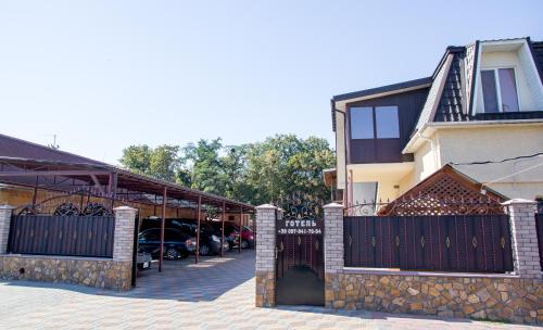 a building with a gate in front of a parking lot at Готель-ГАЙСИН-Ресторан in Haysyn