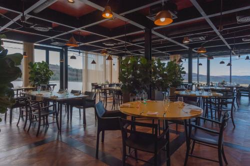 a dining room with tables and chairs and windows at Winery & Design hotel ROXANICH in Motovun