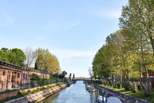 a river with trees and a bridge in the distance at Hotel Indigo Venice - Sant'Elena by IHG in Venice
