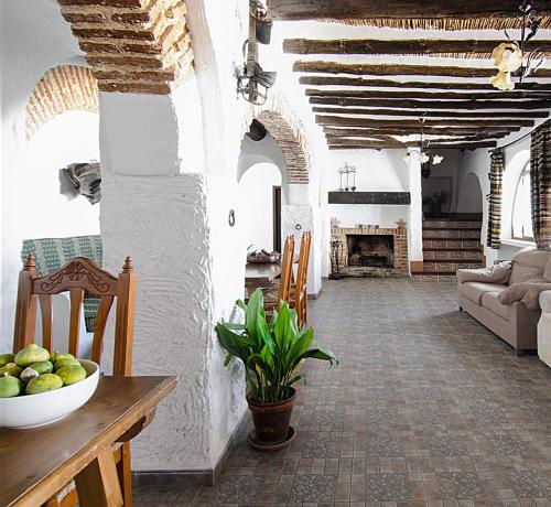 een woonkamer met een bank en een tafel met een fruitschaal bij Cortijo Alzamigaja in Archidona