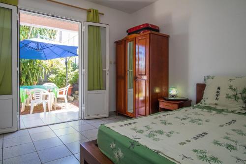 a bedroom with a bed and an open door to a patio at Capucine Location in La Saline les Bains