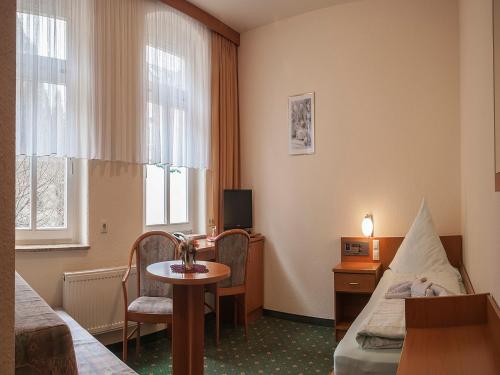 a hotel room with a bed and a desk and a table at Land-gut-Hotel Cafe Meier in Kurort Oybin