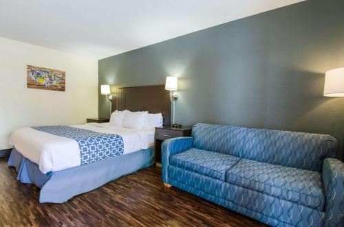 a hotel room with a bed and a couch at Econo Lodge Near Motor Speedway in Bristol