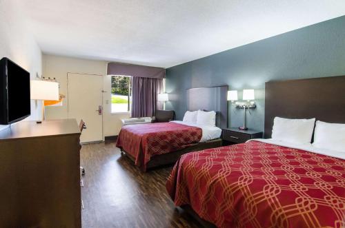 a hotel room with two beds and a flat screen tv at Econo Lodge Near Motor Speedway in Bristol