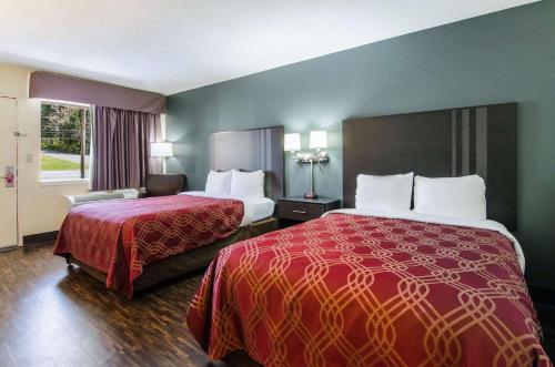 a hotel room with two beds and a window at Econo Lodge Near Motor Speedway in Bristol