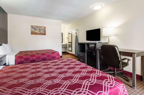 a hotel room with a bed and a desk with a computer at Econo Lodge Near Motor Speedway in Bristol