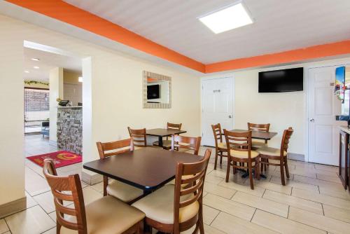 a dining room with tables and chairs and a television at Econo Lodge Near Motor Speedway in Bristol