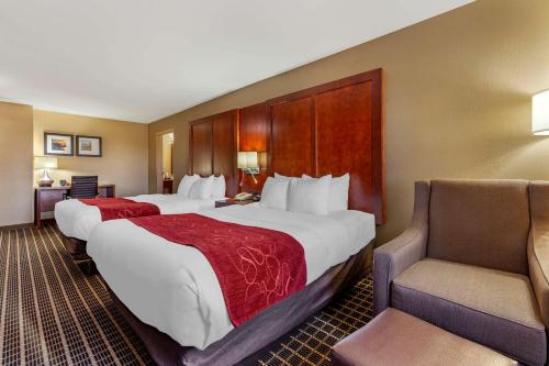 um quarto de hotel com duas camas e uma cadeira em Comfort Suites Delavan - Lake Geneva Area em Delavan