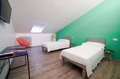 2 Betten in einem Zimmer mit grünen Wänden in der Unterkunft B&B Luci di Stelle in Saluzzo