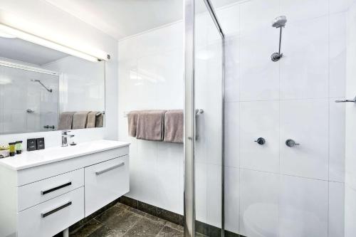a white bathroom with a shower and a sink at Quality Inn Ashby House Tamworth in Tamworth