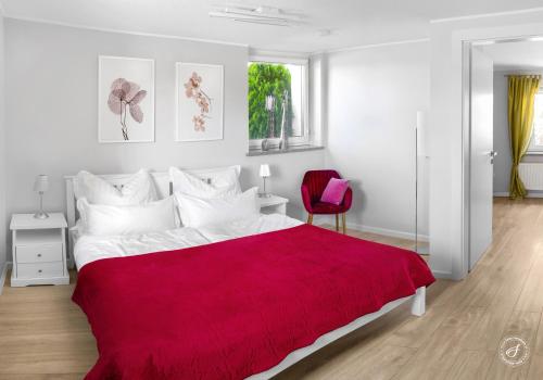 ein Schlafzimmer mit einem großen Bett mit einer roten Decke in der Unterkunft Agrodomek - komfortowy Apartament na Górnym Śląsku in Cisek