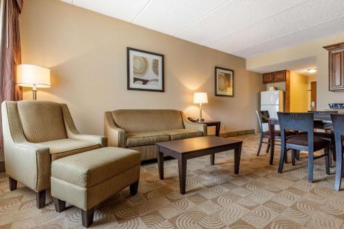 a living room with chairs and a table and a kitchen at Comfort Inn Warner Robins - Robins Air Force Base Area in Warner Robins