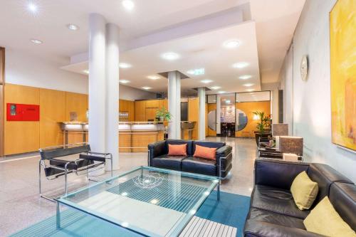 a living room with couches and a glass table at Comfort Hotel Atlantic Muenchen Sued in Ottobrunn