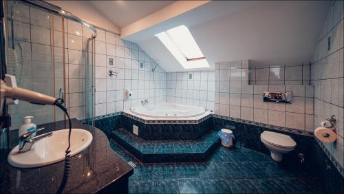 a bathroom with a tub and a toilet and a sink at Euphoria Residence in Sosnowiec