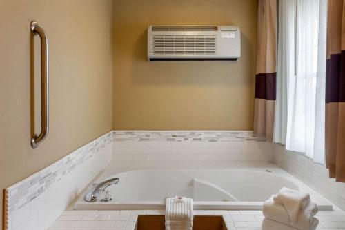 a bathroom with a bath tub with a air conditioner at Comfort Inn Marshall Station in Marshall