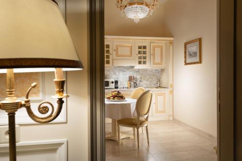a kitchen with a table and chairs and a refrigerator at Savoy Westend Hotel in Karlovy Vary