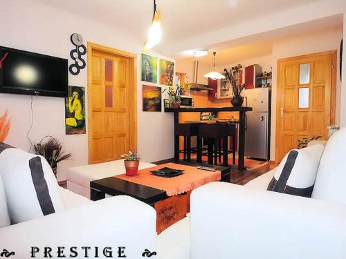 a living room with two white couches and a kitchen at Apartment Centar in Sarajevo