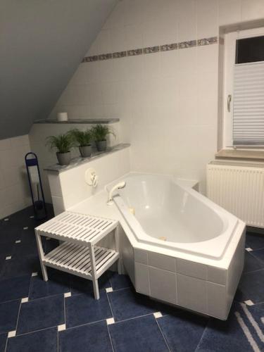 a white bath tub in a bathroom with blue tiles at Ferienhaus Morgensonne in Neustadt in Sachsen