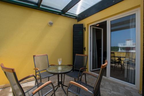 a patio with a table and chairs and a balcony at Villas Faro in Bašanija