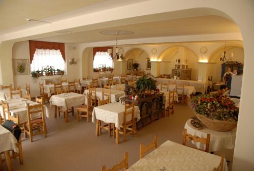una sala da pranzo con tavoli e sedie bianchi di Albergo Adele a Bormio
