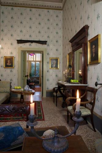 a living room with a couch and a table with candles at Residenza d'Epoca Regina d'Arborea in Oristano